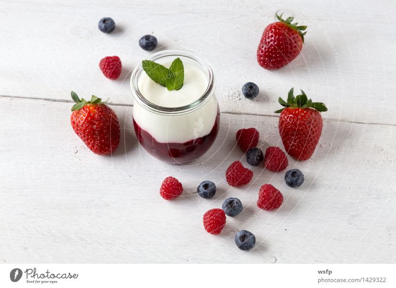 Rote Grütze mit Minze Joghurt Frucht Dessert Holz weiß rote Grütze Himbeeren Blaubeeren weisser Holzhintergrund Erdbeeren Glas Gesund Süsspeise Essen Holztisch