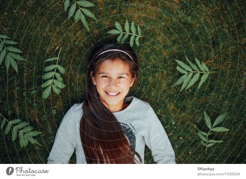 Kleines Mädchen, das auf dem Gras und dem Lächeln liegt Kind 1 Mensch 8-13 Jahre Kindheit genießen lachen liegen einfach frei Glück schön klein lustig neu