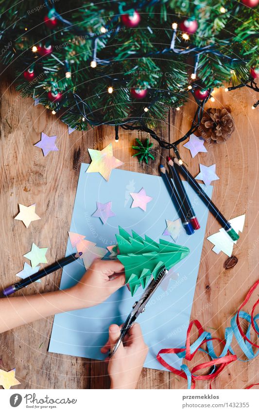 Mädchen, das Weihnachtsbaumdekoration vom Papier macht Handarbeit Dekoration & Verzierung Tisch Schere 1 Mensch Baum Holz Ornament Kreativität Weihnachten