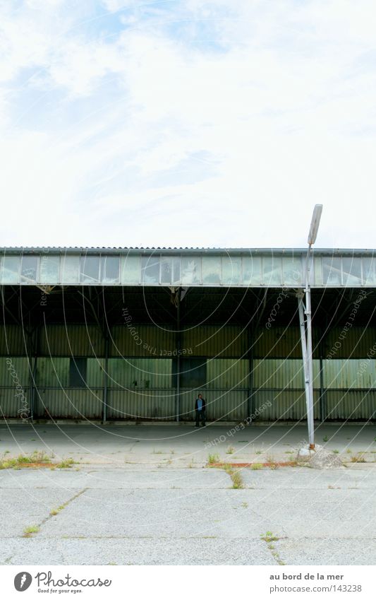 Tristesse. Mann Kontrast Laterne trist grau blau Lagerhalle alt Täuschung Industrie Verkehrswege Langeweile Himmel