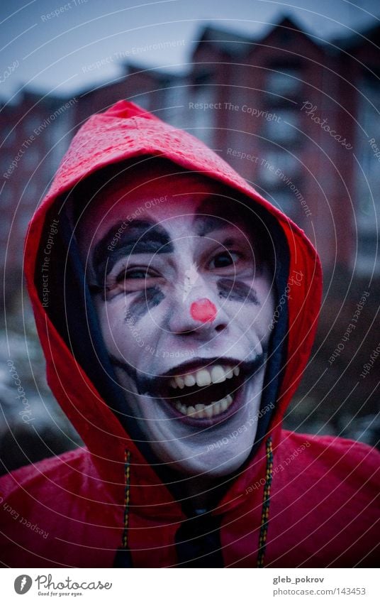 Verrückter Clown. Porträt Mann Zähne Regen Straße Müll Nase Bekleidung Sibirien Luft Kapuze Sturmhaube Hoodoos Kopf Hut Freude Mensch grimmig Männer gedacht rot