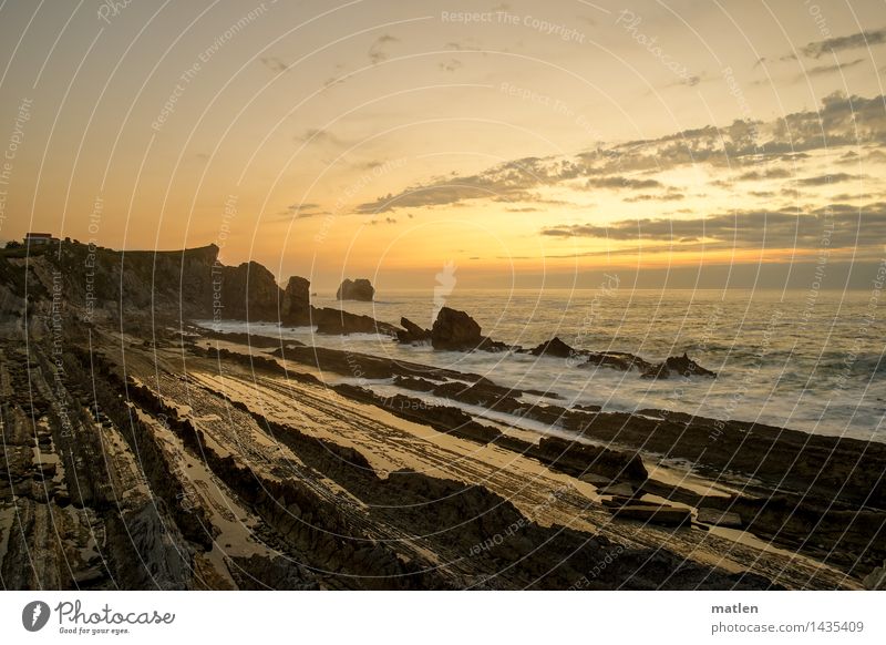 lateral Natur Landschaft Himmel Wolken Horizont Sonnenaufgang Sonnenuntergang Klima Wetter Schönes Wetter Felsen Schlucht Wellen Küste Riff Meer blau braun gold