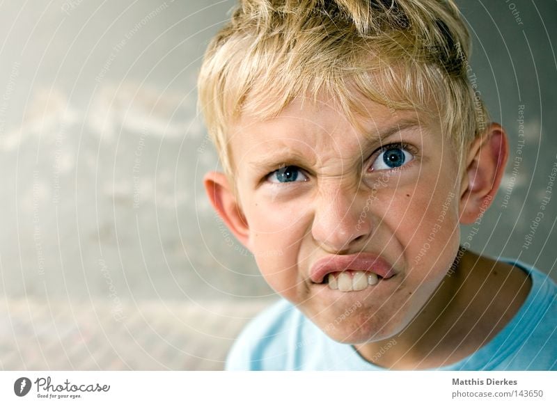 Spitzbube klein Kind blond zerzaust Schüchternheit T-Shirt Hintergrundbild Wand Putz Asphalt geblitzt rot errötet ruhig Pause Porträt Freundlichkeit Philosoph