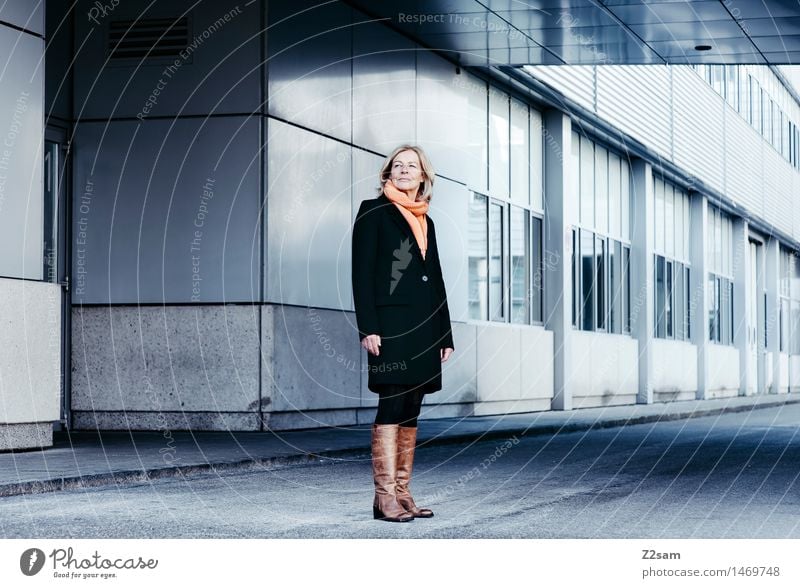 Schulterblick feminin Weiblicher Senior Frau 1 Mensch 45-60 Jahre Erwachsene Bauwerk Gebäude Architektur Mantel Schal Stiefel blond Blick stehen warten Coolness