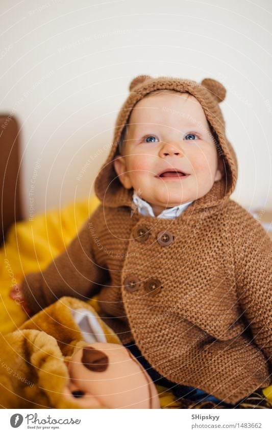 Kleiner Junge, der auf dem Bett und dem Lächeln sitzt Geburtstag Mensch Kind Baby Leben 1 1-3 Jahre Kleinkind berühren Bewegung lachen sitzen Spielen Farbfoto