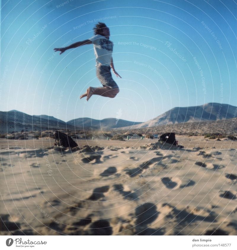 stay high Mensch springen Strand Sand Wüste Horizont blau Fußspur Freude hoch Himmel Mitte Tasche Fuerteventura Querformat Rollfilm Berge u. Gebirge sotavento