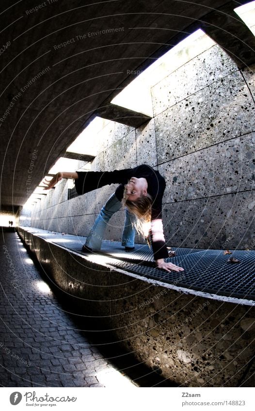 stretch Tunnel Beton Durchgang London Underground Untergrund Licht Schatten dunkel hell Strahlung Frau feminin blond gelenkig Stil Fischauge Gitter Stein Mauer