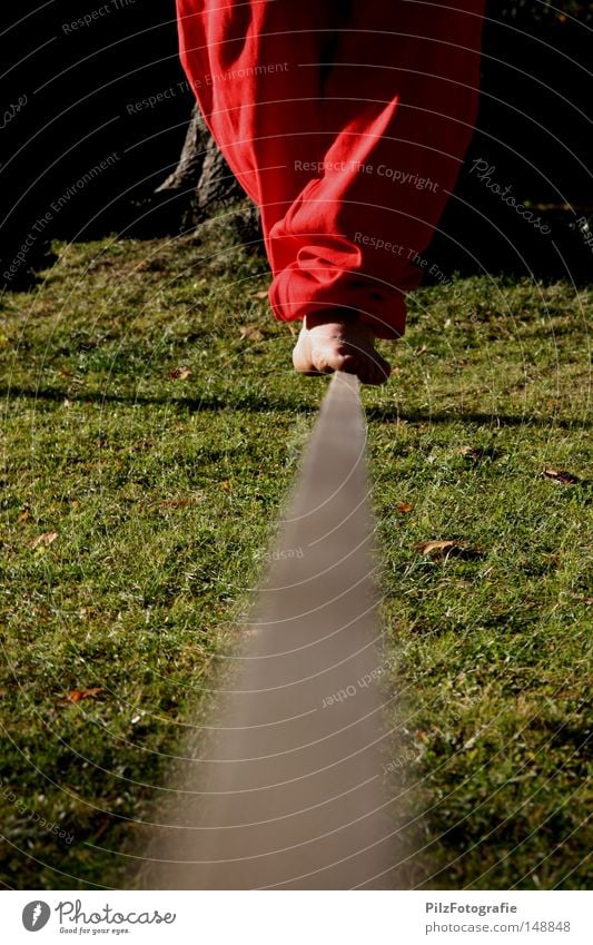 Seiltanz Zufriedenheit Gleichgewicht Schnur rot Hose Fuß schwarz Baum Wiese Unschärfe Verlauf Mitte Barfuß Schatten Tanzen Vertrauen Konzentration Gedanke