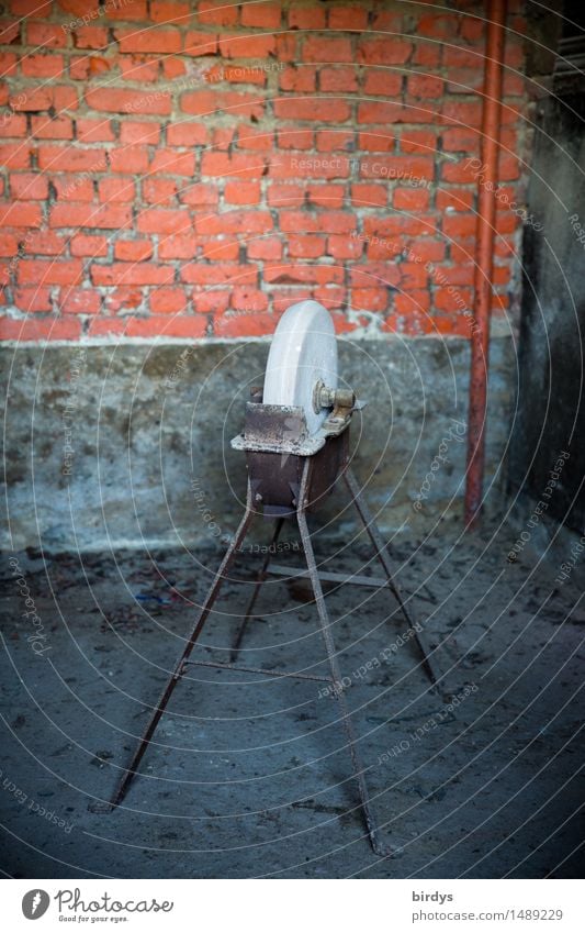 Alter Schleifstein mit Metallgestell Handwerker alte Berufe Schleifmaschine Arbeitsplatz schärfen Werkstatt Mauer Wand authentisch historisch Originalität blau