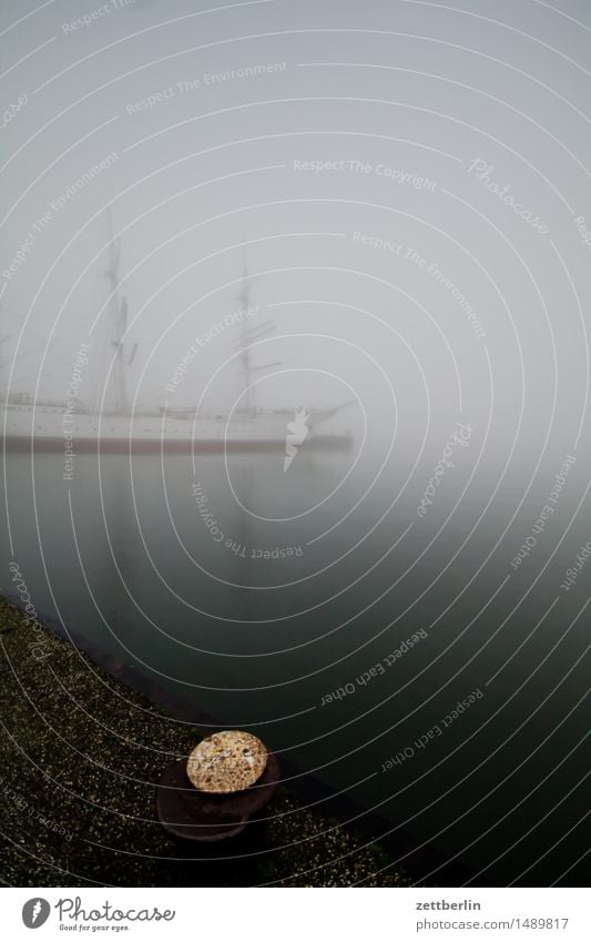 Schiff im Nebel Wasserfahrzeug Segelschiff Segelboot Mast Segeln Segeljacht Hafen Anlegestelle Dunst Wetter Winter ruhig trüb Perspektive Windstille Seil Tau