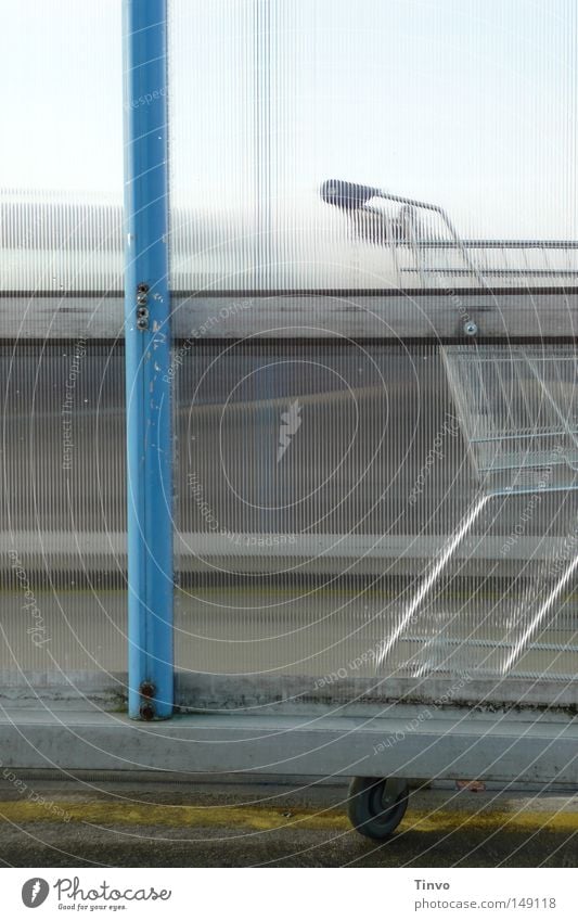 Leihwagen abgeschoben parken blau Einkaufswagen Einkaufszentrum Euro Garage Gitter grün Grünspan hell-blau Kunststoff matt Metall trist Ödland Parkdeck warten