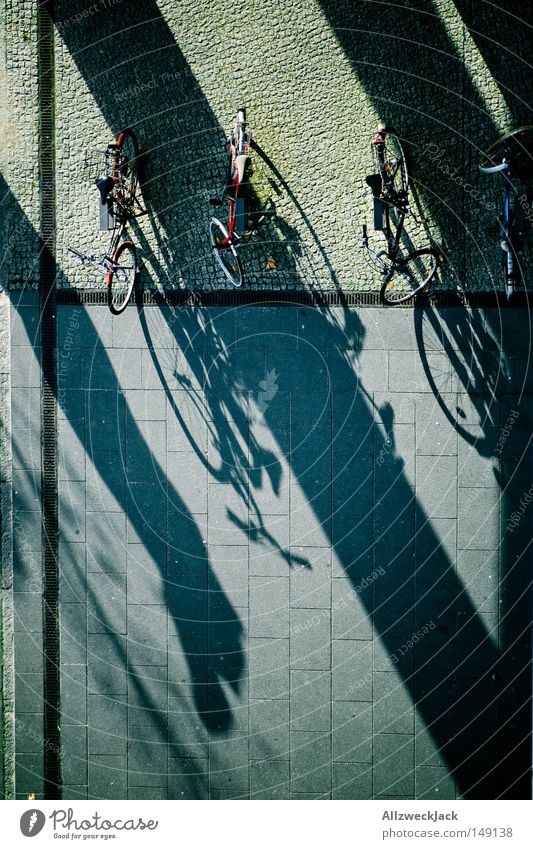 Schattenparker Vogelperspektive Fahrrad Bürgersteig Muster Fahrradparkplatz parken Herbst Verkehr Pflastersteine