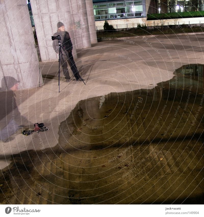 BLN08_Flut fotografieren in der Nacht Fotokamera Mensch Mann Winter Säule Mütze Beton beobachten kalt Neugier Interesse Konzentration Boden Pfütze Fotograf