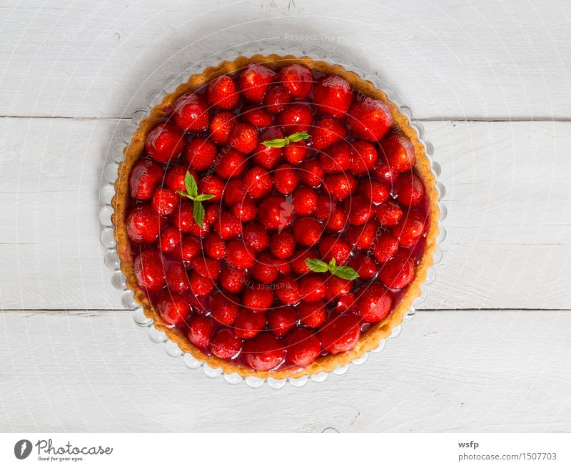 Erdbeerkuchen mit Minze auf weißem Holz Kuchen Dessert Erdbeeren Backwaren klassisch Tortenguss Biskuit Holztisch Landhaus rustikal Vogelperspektive