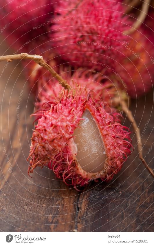 frische tropische Rambutanfrüchte über rustikaler hölzerner Tabelle Frucht Dessert Ernährung exotisch Menschengruppe Natur Pflanze lecker natürlich saftig rot