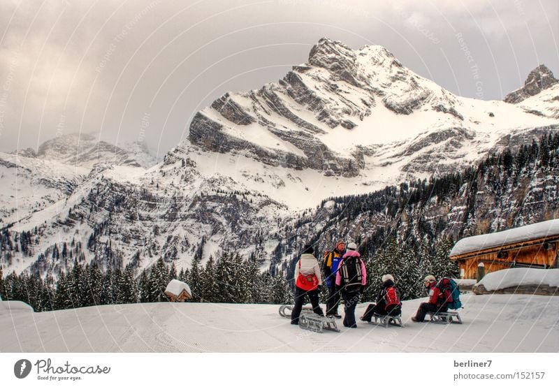 Farbtupfer am Ortstock Berge u. Gebirge Winter Rodeln Schlitten Wintersport Alpen glarner land braunwald Schnee Schneelandschaft Menschengruppe Berghütte