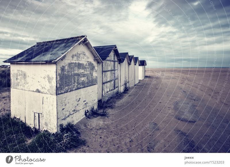 Reihenhaussiedlung Landschaft Wolken schlechtes Wetter Strand Haus Hütte alt kalt klein Horizont Idylle Verfall Häusliches Leben Farbfoto Gedeckte Farben