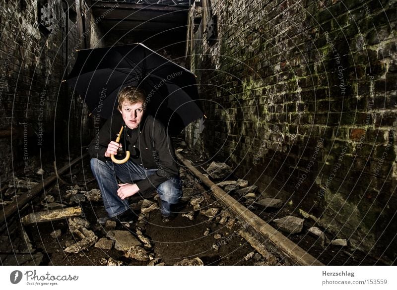 Umbrella for Men dreckig Höhle Stein Gleise Regenschirm Schutzdach Jeanshose Mann Macho Mauer Angeben Frau werben Kraft