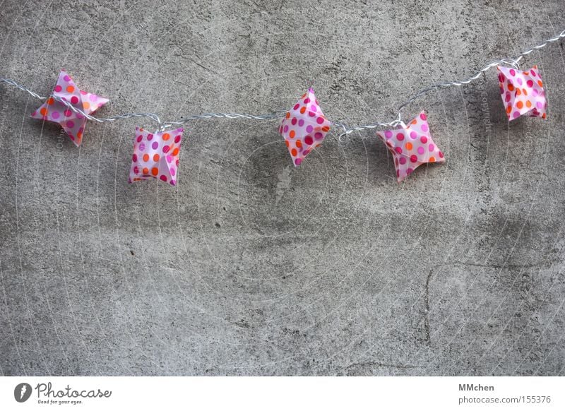 bunte Lichterkette mit roten und orangen Punkten vor grauer Betonwand gemütlich wohnlich Dekoration & Verzierung Einladung einladend mehrfarbig trist Farbfleck