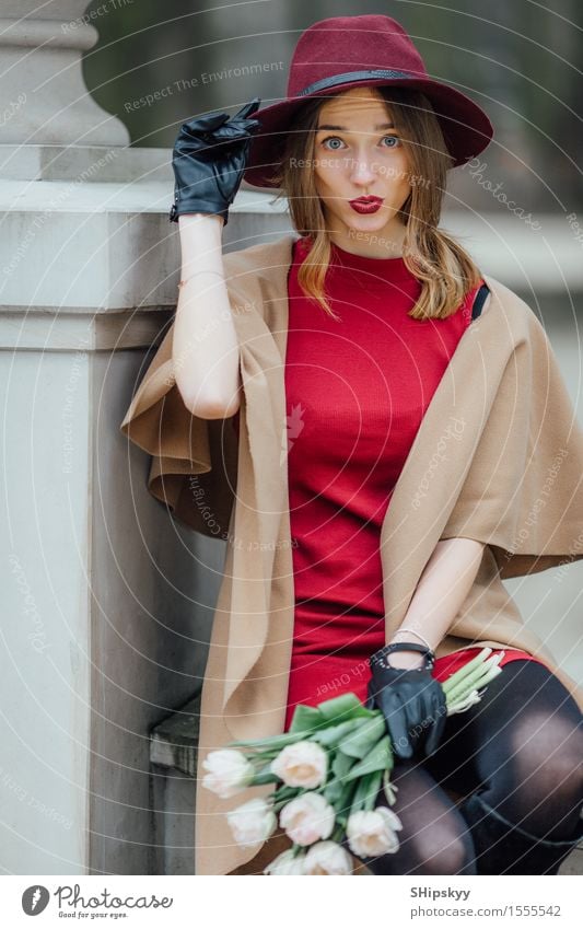 Frau, die auf dem Parkhintergrund mit weißen Blumen sitzt elegant Stil schön Mensch Mädchen Erwachsene Lippen Wetter Tulpe Mode Bekleidung Pullover Pelzmantel