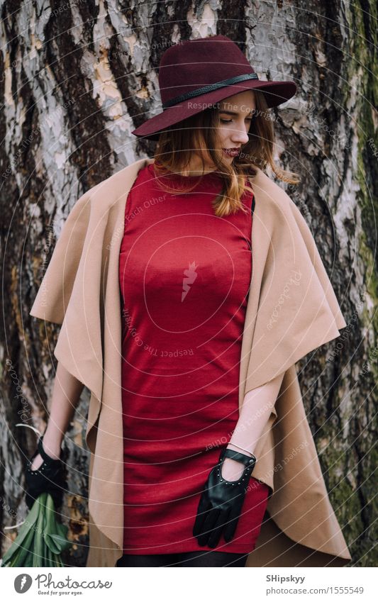 Frau, die auf dem Parkhintergrund mit Blumen steht elegant Stil schön Garten Mensch Mädchen Erwachsene Natur Wetter Tulpe Mode Bekleidung Pullover Pelzmantel