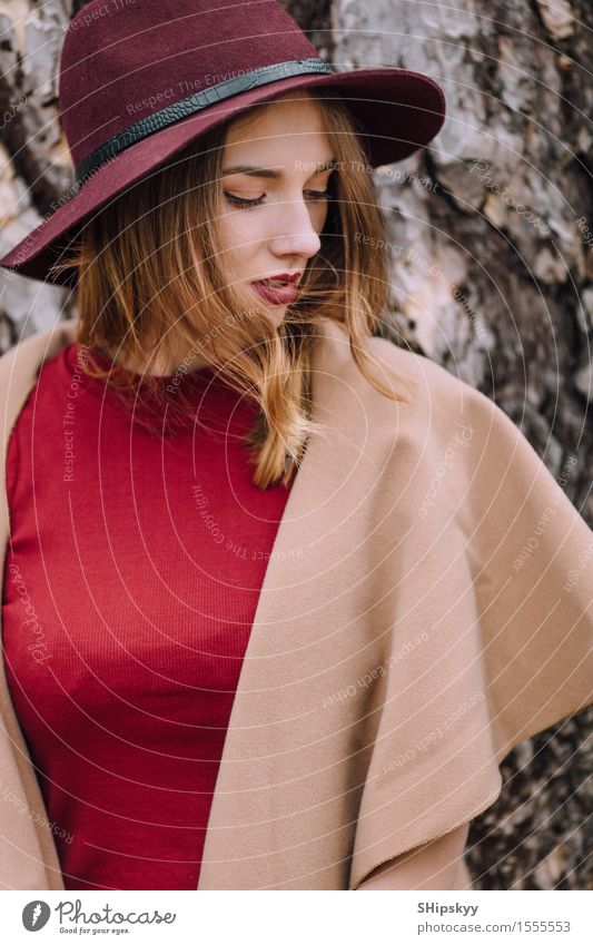 Frau, die auf dem Parkhintergrund mit Blumen steht elegant Stil schön Garten Mensch Mädchen Erwachsene Natur Wetter Tulpe Mode Bekleidung Pullover Pelzmantel