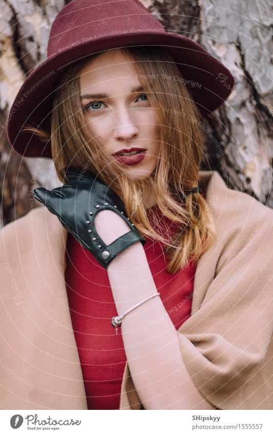 Frau, die auf dem Parkhintergrund mit Blumen steht elegant Stil schön Garten Mensch Mädchen Erwachsene Natur Wetter Tulpe Mode Bekleidung Pullover Pelzmantel