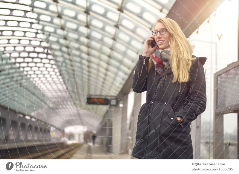 Blonde Frau mit Handy an der Bahnstation Glück Gesicht Winter Telefon PDA feminin Erwachsene 1 Mensch 18-30 Jahre Jugendliche Verkehr