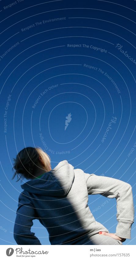 Lichtspiel auf Blau. Frau blond Schatten grau Kapuze Blauer Himmel Sommer Hochsteckfrisur Rücken Kontrast Hoodie rückwärts