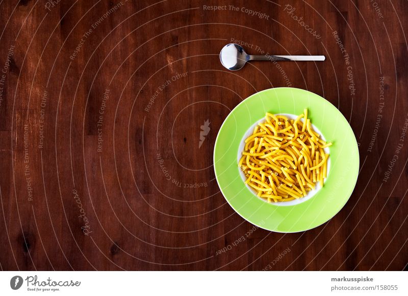 pasta roh Nudeln Spaghetti Teigwaren lang dünn Besteck Löffel Teller grün rund Holztisch Gastronomie Vegetarische Ernährung Geschirr