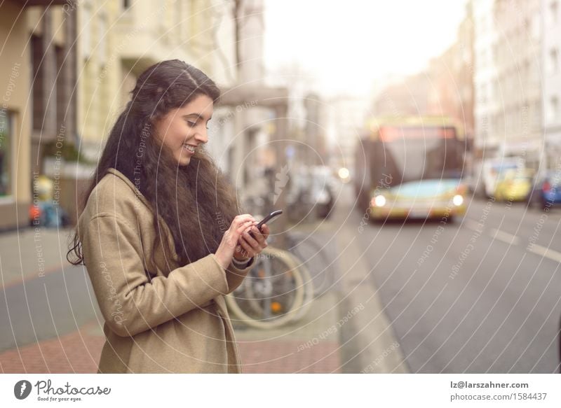 Brunettefrau, die an ihrem Handy simst Glück schön Gesicht lesen Business Telefon PDA Technik & Technologie Mensch Frau Erwachsene 1 18-30 Jahre Jugendliche