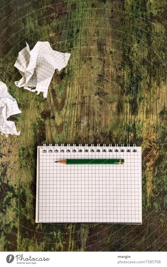 Einfallslos! Leere zerknüllte Notizblätter mit einem leeren Schreibblock mit karierten Papier und einen Bleistift auf einem alten Holztisch