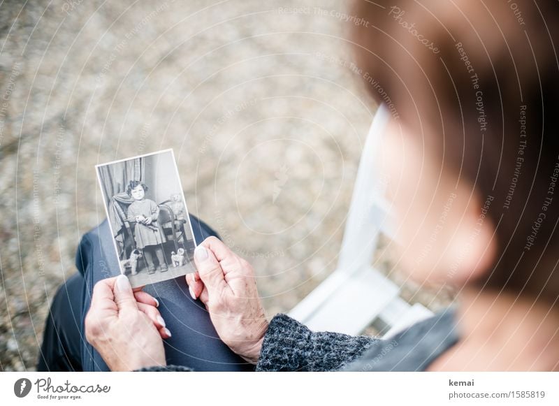 Ältere Frau schaut auf Schwarz-Weiß-Bild von sich als Kind Mensch feminin Erwachsene Weiblicher Senior Familie & Verwandtschaft Kindheit Leben Hand 1