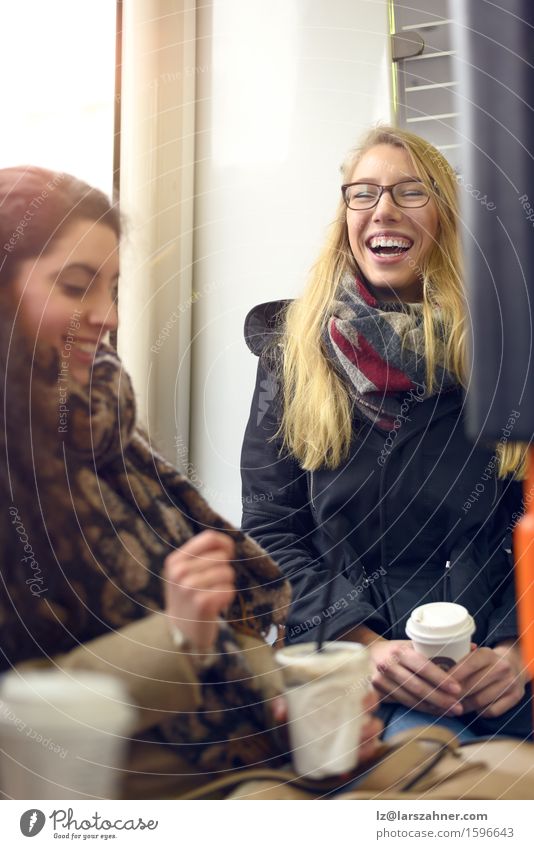 Zwei sitzende blonde und brünette Freunde Kaffee Glück Frau Erwachsene Freundschaft 2 Mensch 18-30 Jahre Jugendliche Brille Schal lachen attraktiv heiter