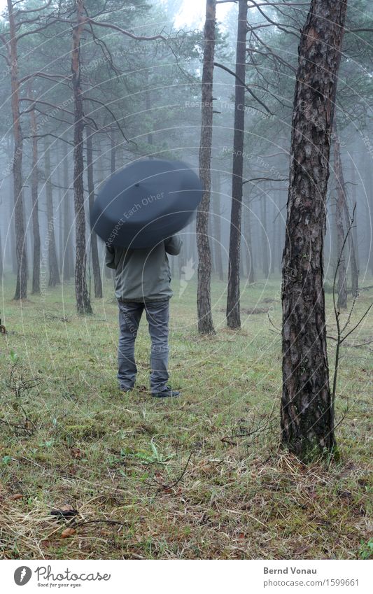 drehung Mensch 1 Jacke braun grau grün Schirm Regenschirm Drehung stehen Blick warten Spielen Langeweile Farbfoto Außenaufnahme Textfreiraum unten Tag