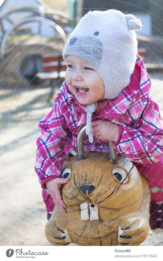 Ride on a hamster feminin Kind Kleinkind Mädchen Kindheit 1 Mensch 1-3 Jahre Abenteuer Freude Mütze Spielplatz Reiten lachen grinsen Farbfoto Außenaufnahme Tag