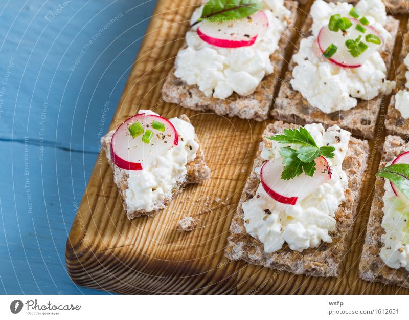 Knäckebrot mit Hüttenkäse Radieschen und Kräutern Kräuter & Gewürze Holz blau Frischkäse Schnittlauch Dill Petersilie rote bete blätter Holzbrett Snack