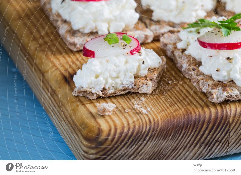 Knäckebrot mit Hüttenkäse Radieschen und Kräutern Kräuter & Gewürze Holz blau Frischkäse Schnittlauch Dill Petersilie rote bete blätter Holzbrett Snack