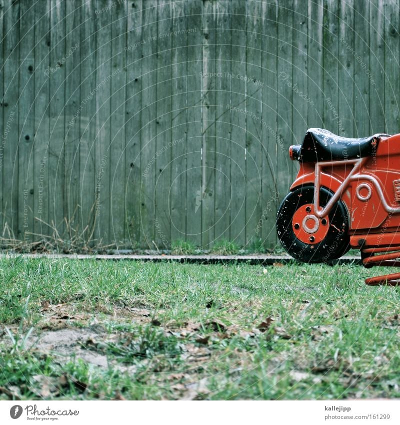 feuerrotes spielmobil Spielplatz Motorrad Metallfeder Spielen Kindheit Spielzeug Kindheitstraum Geschwindigkeit Holzwand Rasen Sportrasen Wiese alt Wippe