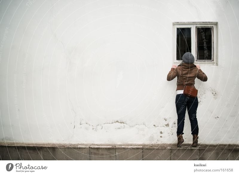 Fenster. Blick spionieren entdecken Perspektive Fensterscheibe Scheibe Regen kalt Mütze Voyeurismus Spitzel Wand Frau