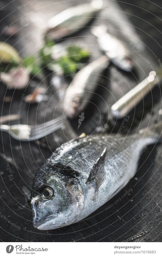 Rohe Seebrassenfische auf Dunkelheit Meeresfrüchte Mittagessen Abendessen Diät Gastronomie Holz dunkel frisch lecker schwarz weiß roh Goldbrasse geschmackvoll