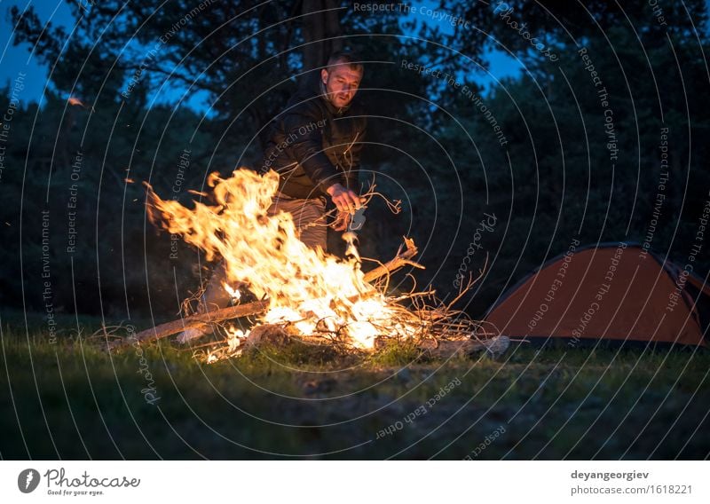 Mann beleuchtet ein Feuer im Kamin in der Natur nachts Freizeit & Hobby Ferien & Urlaub & Reisen Tourismus Abenteuer Camping Sommer Berge u. Gebirge wandern