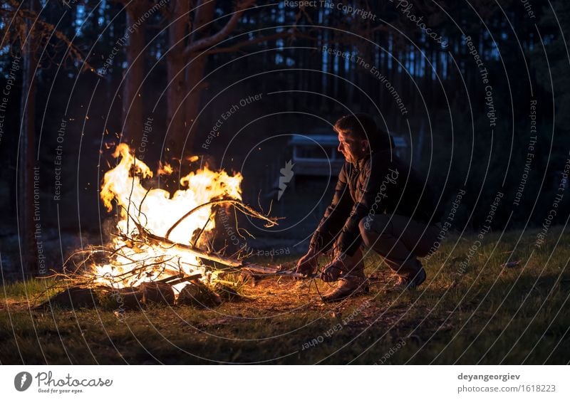 Mann beleuchtet ein Feuer im Kamin in der Natur nachts Freizeit & Hobby Ferien & Urlaub & Reisen Tourismus Abenteuer Camping Sommer Berge u. Gebirge wandern