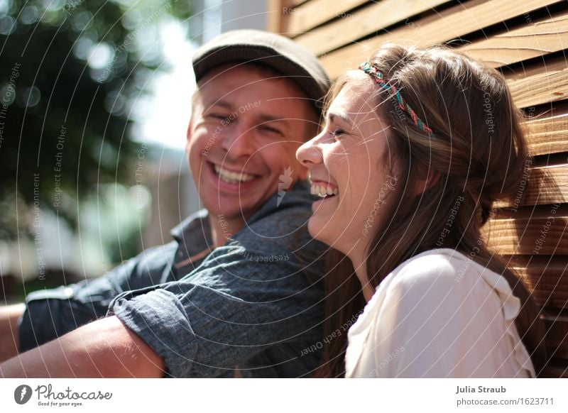 Mann und Frau lachen herzlich im sitzen lehnend an einer Wand mit Rhombuschleisten Hochzeit Paar Partner Leben 2 Mensch 30-45 Jahre Erwachsene Sonne Sommer