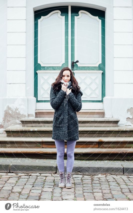 Junger Frau ist kalt Sightseeing Winter Haus Student feminin Junge Frau Jugendliche Erwachsene 1 Mensch 18-30 Jahre Architektur Tür Jacke Mantel brünett