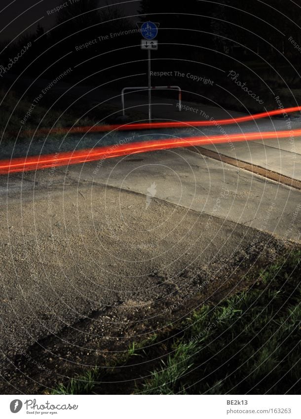 Da wenn einer kommt.... Nacht Rücklicht PKW Lichtstreifen Straße Straßenverkehr Bürgersteig Fahrradweg Barriere Öffentlicher Dienst Straßennamenschild