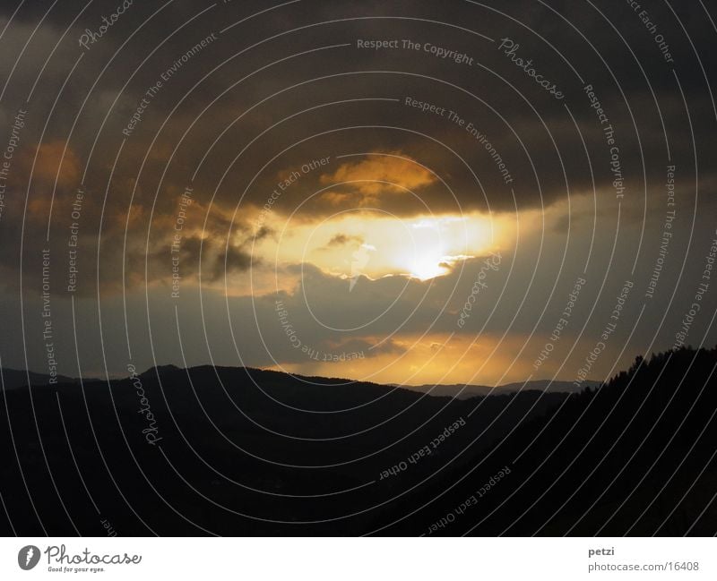 Der Tag geht zu Ende Berge u. Gebirge Wolken Wald gelb grau schwarz Abenddämmerung Sonnenloch Farbfoto Außenaufnahme Textfreiraum oben Textfreiraum unten