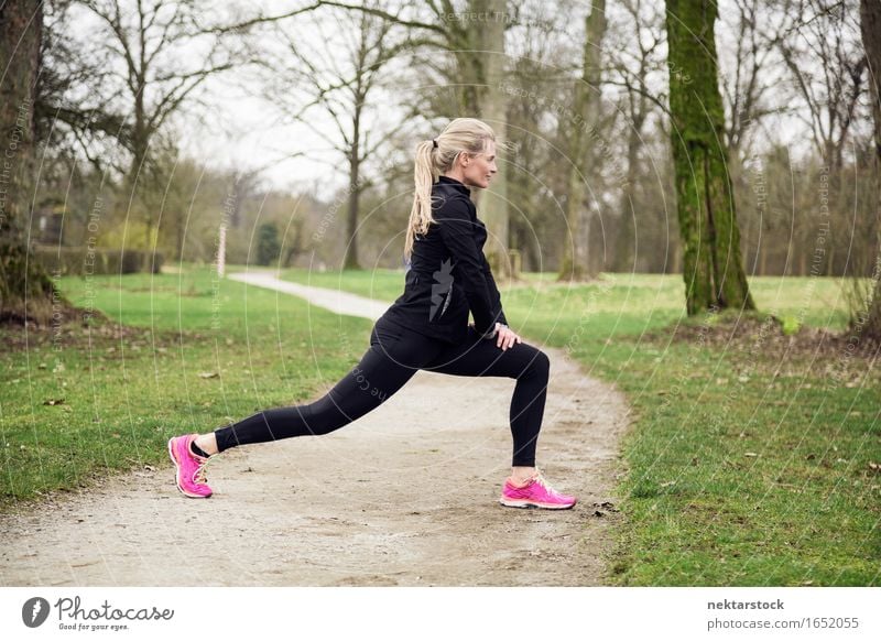 attarcive Frau, die sich im Park ausdehnt. Lifestyle Körper Wellness Winter Sport Mensch Erwachsene Baum Wege & Pfade Fitness sportlich üben Gesundheit Training