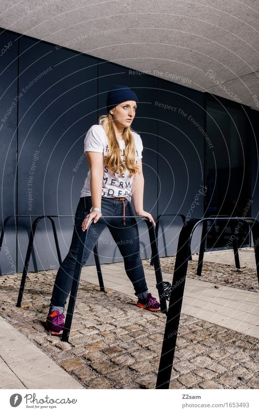 Standhaft bleiben Lifestyle elegant Stil feminin Junge Frau Jugendliche 18-30 Jahre Erwachsene Stadt Mode T-Shirt Jeanshose Turnschuh Mütze blond langhaarig