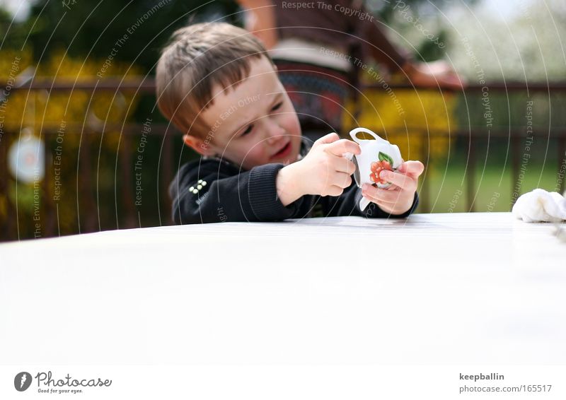 what's that? Farbfoto Außenaufnahme Textfreiraum unten Tag Schwache Tiefenschärfe Zentralperspektive Oberkörper Wegsehen Spielen Basteln Mensch maskulin Kind